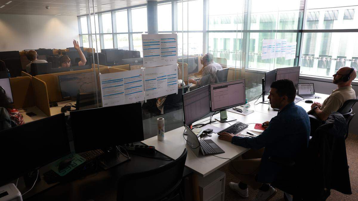 Customer-service staff working with headsets in a call centre office.