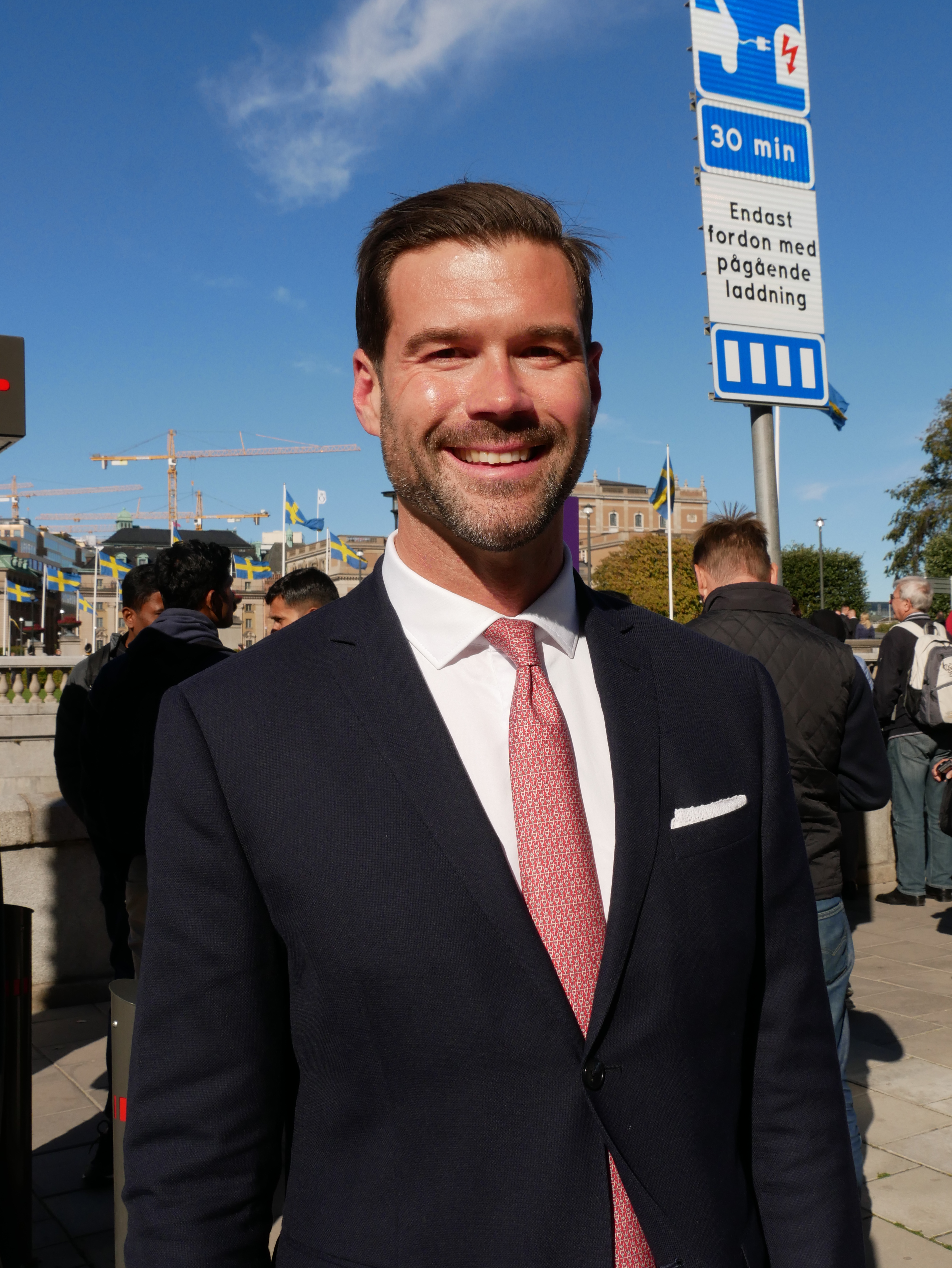 Johan Forssell wearing a dark suit and red tie outside the Riksdag during its 2018 opening.