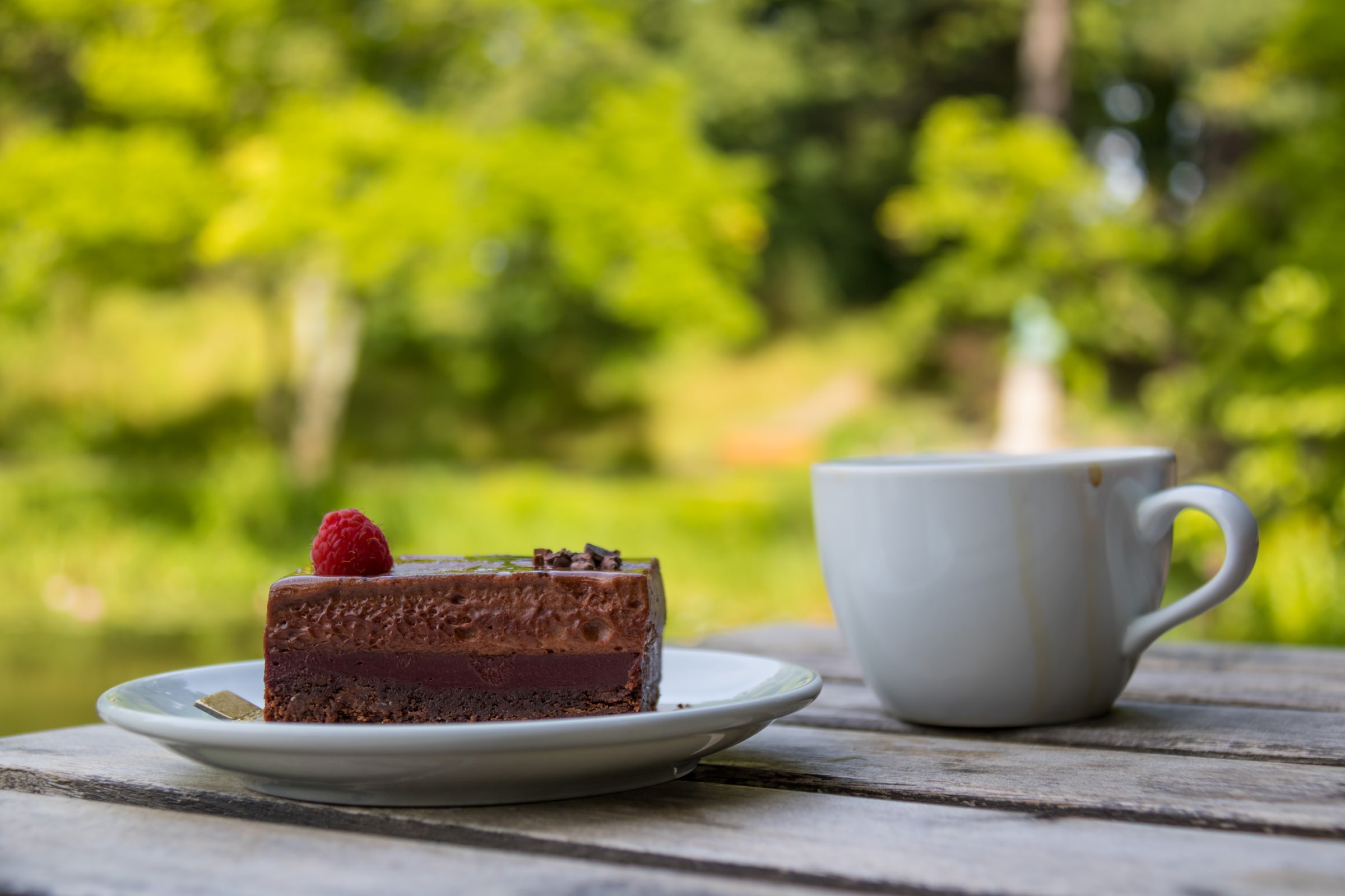 A cup of coffee and a slice of chocolate cake are served outdoors for Swedish fika.