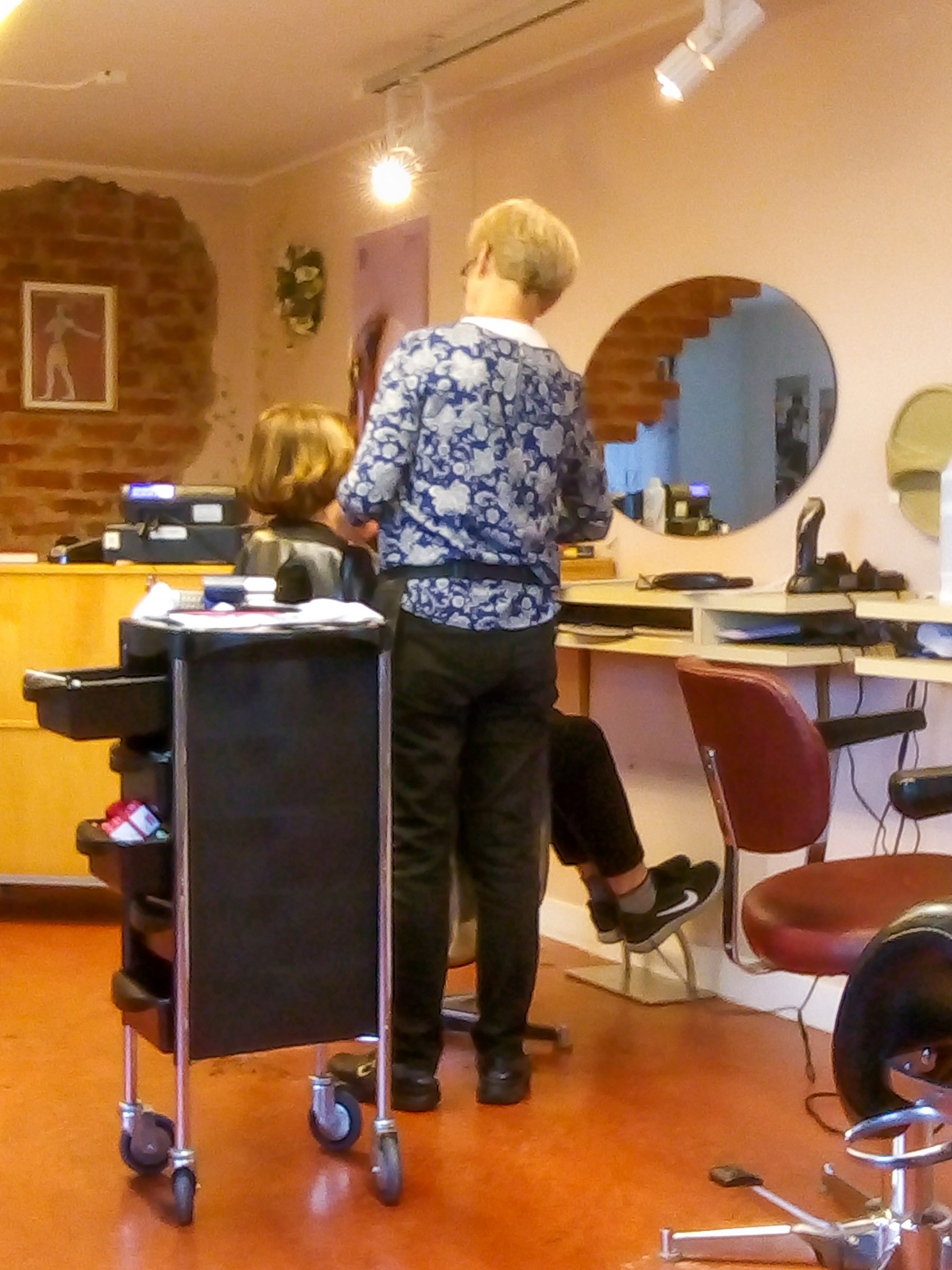 A hairdresser works with a customer in a salon in Brastad, Sweden, in October 2018.