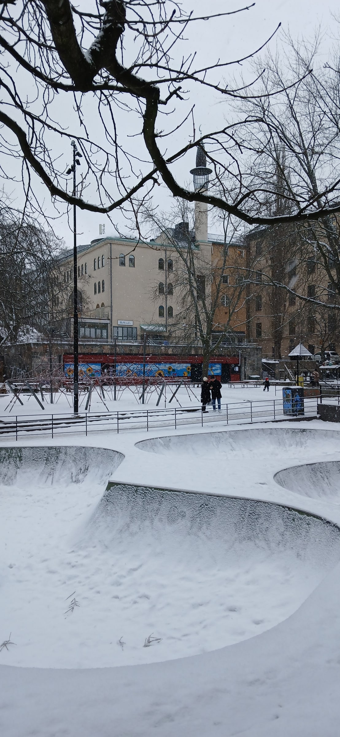 Stockholm Mosque seen across a snow-covered park in winter.