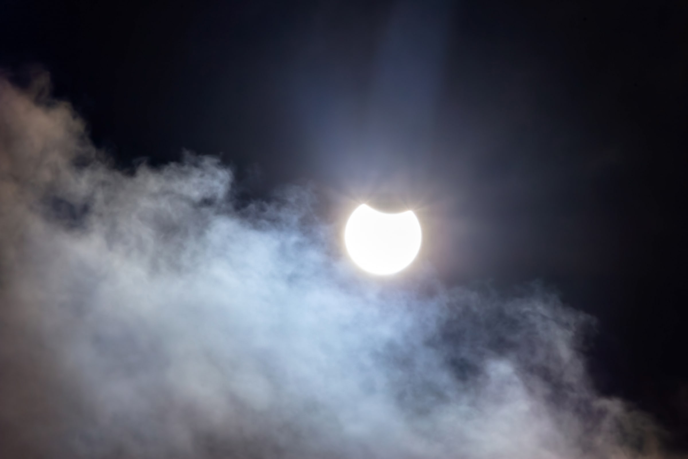 A partial solar eclipse visible through clouds over Tuntorp in western Sweden.