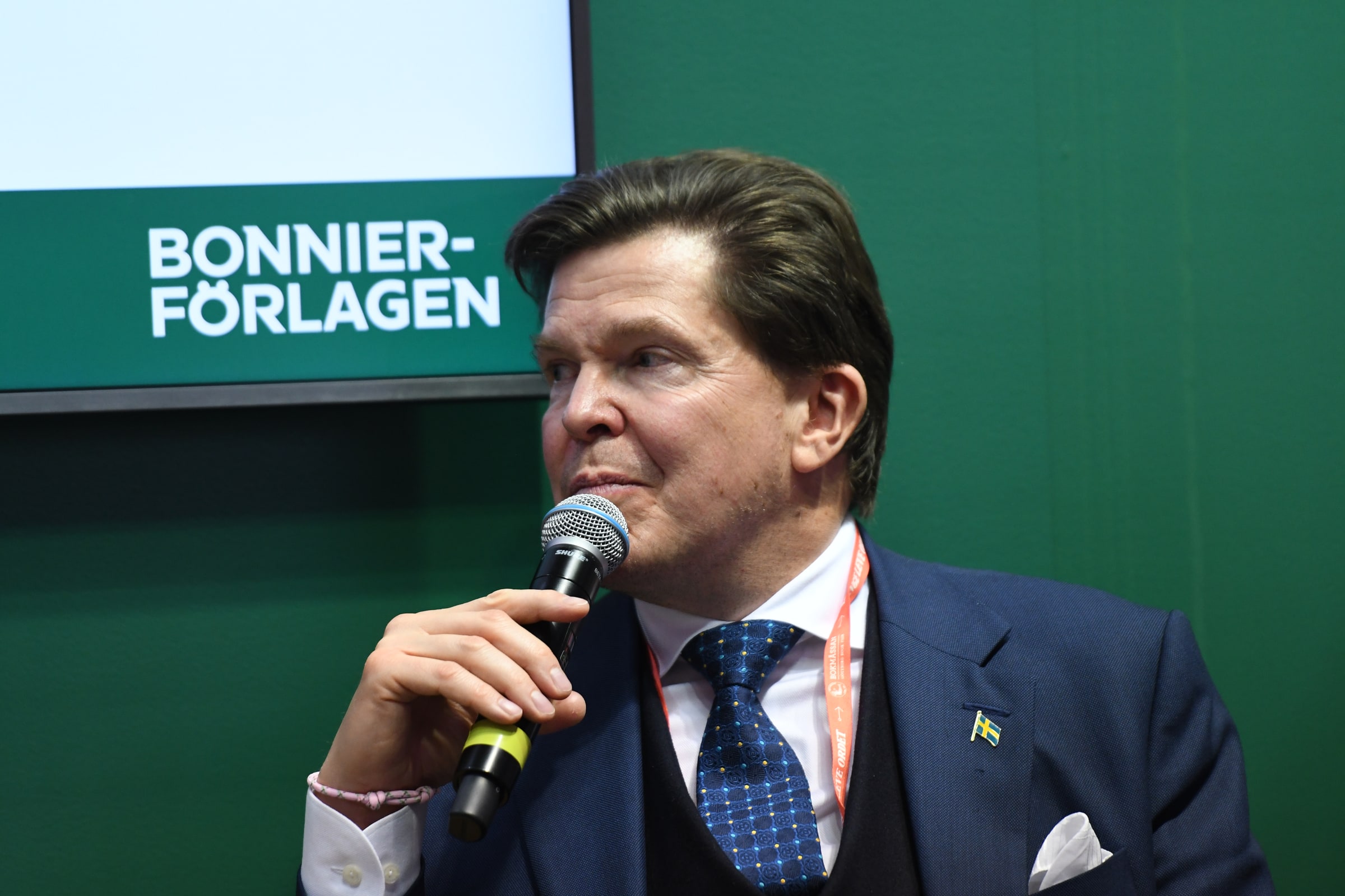 Andreas Norlén speaks into a handheld microphone at the Göteborg Book Fair in September 2025.