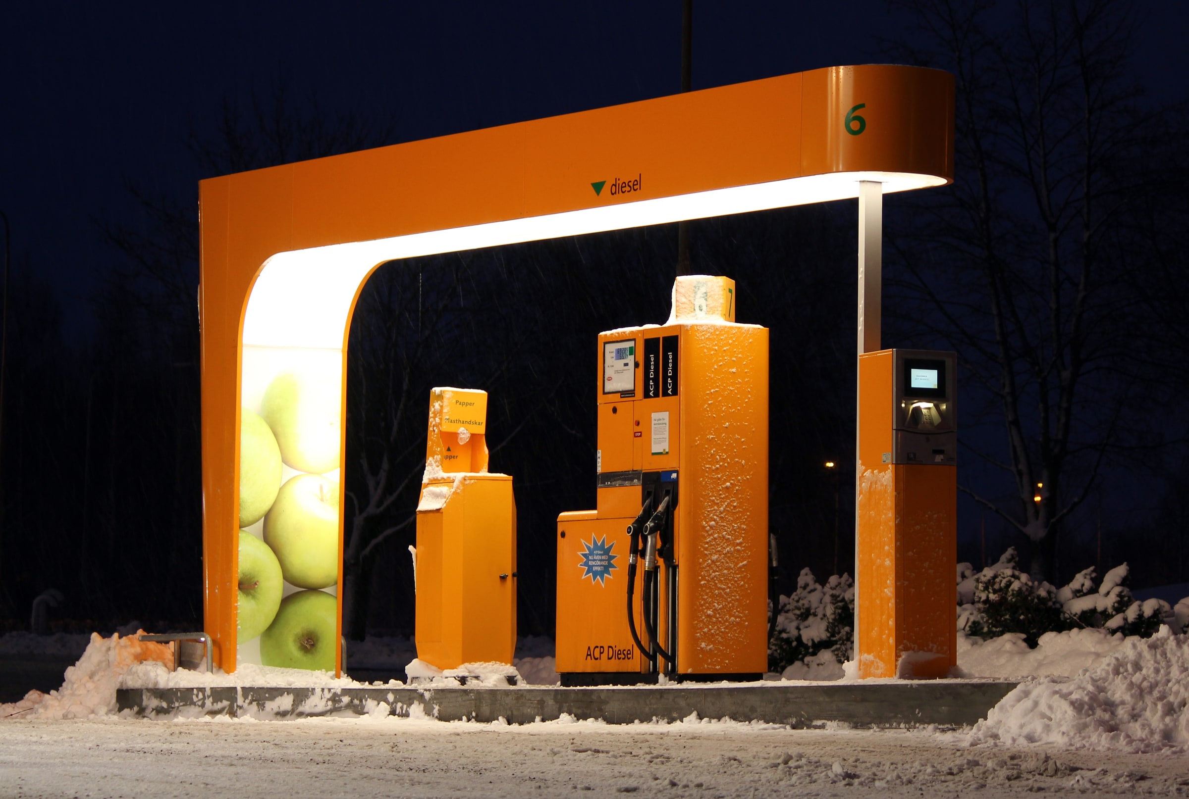 An illuminated diesel dispenser and card-payment terminal at a petrol station in Avesta, Sweden.