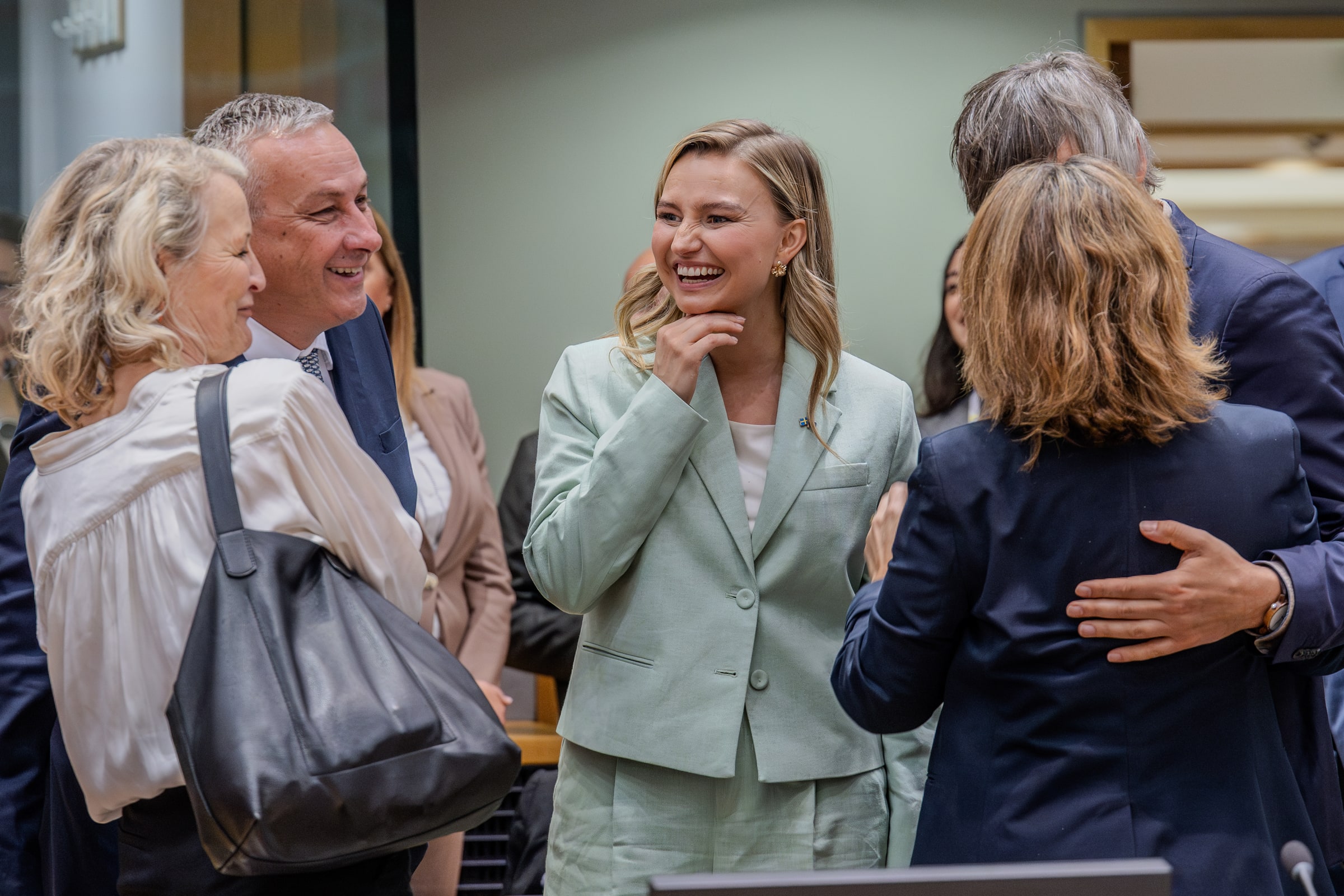 Ebba Busch talks with other participants around a table at an energy council meeting.
