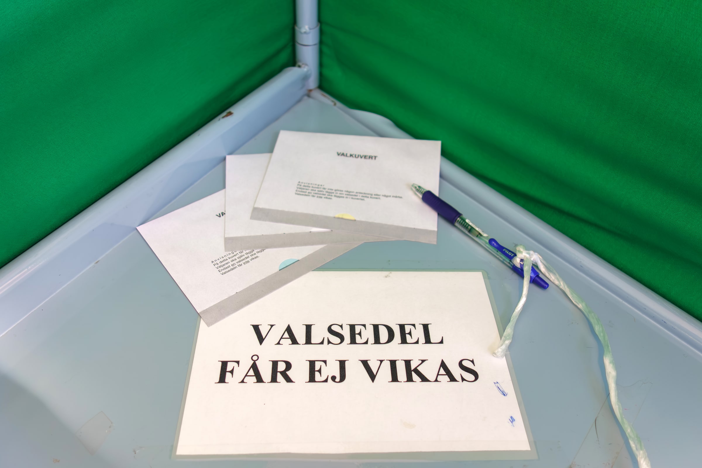 Ballot envelopes and a pen inside a green polling booth in Brastad.