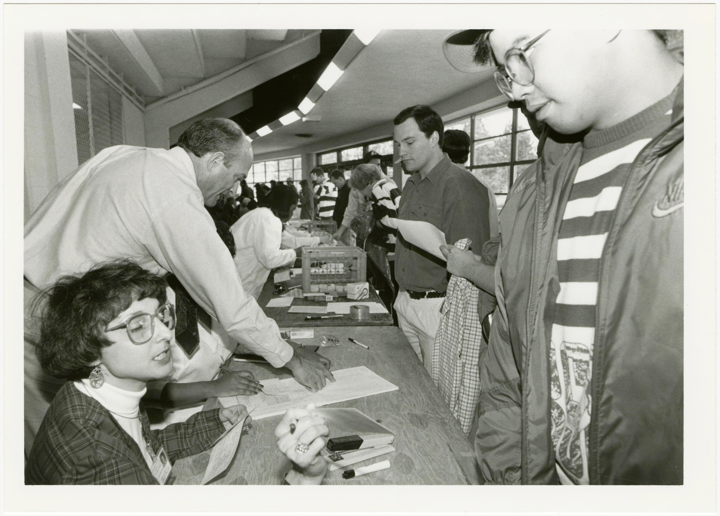 An archival black-and-white photograph shows a clinician administering a measles vaccination during a campaign at the University of Mississippi.