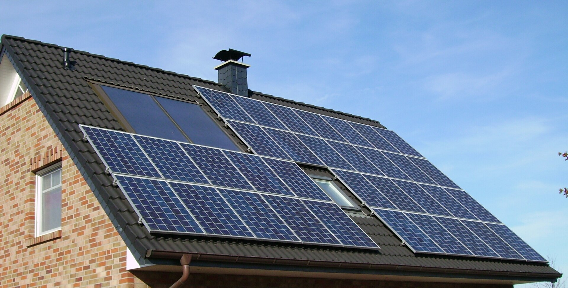 Rows of photovoltaic solar panels installed across a sloping roof.