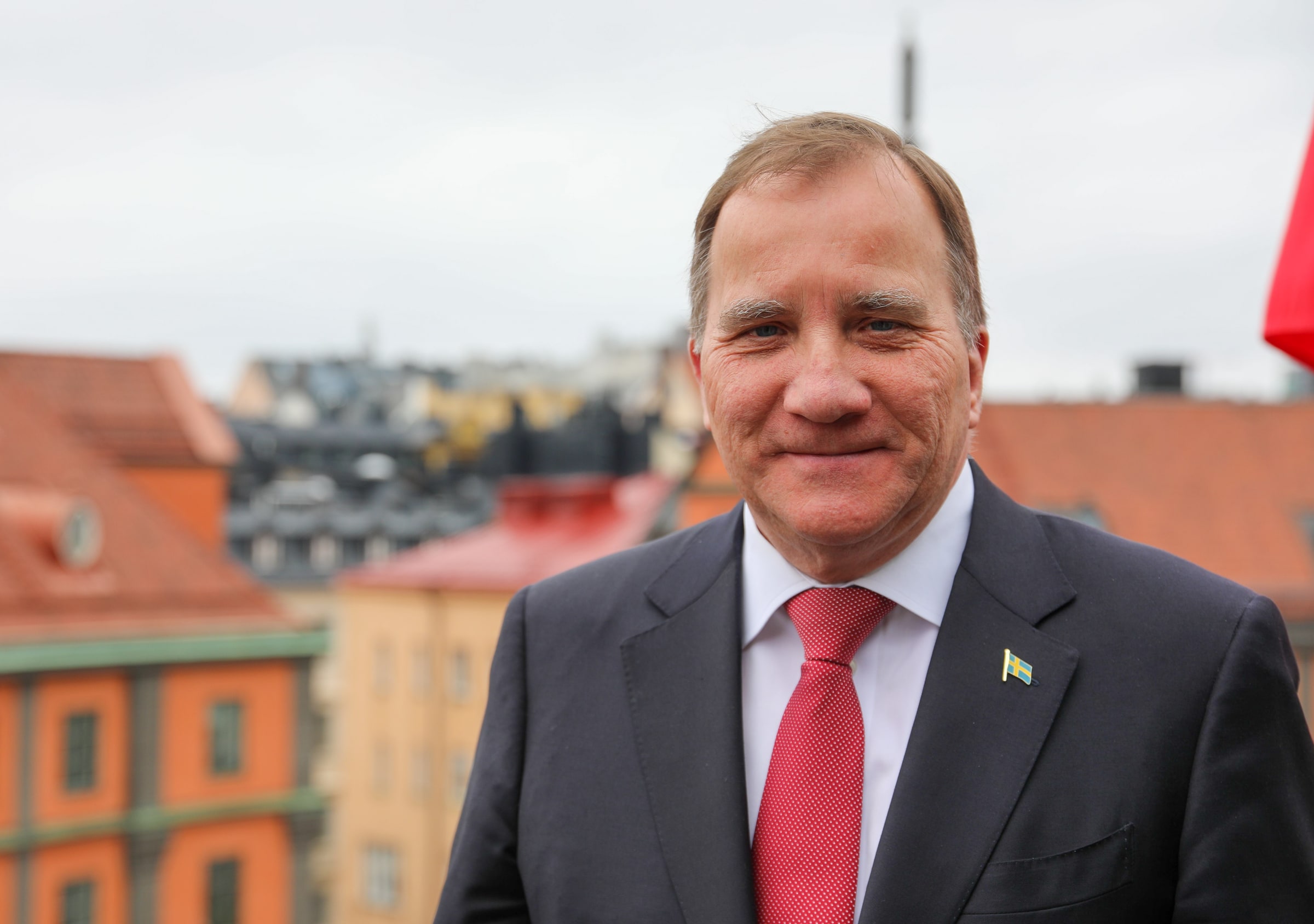 Stefan Löfven in a dark suit and red tie.
