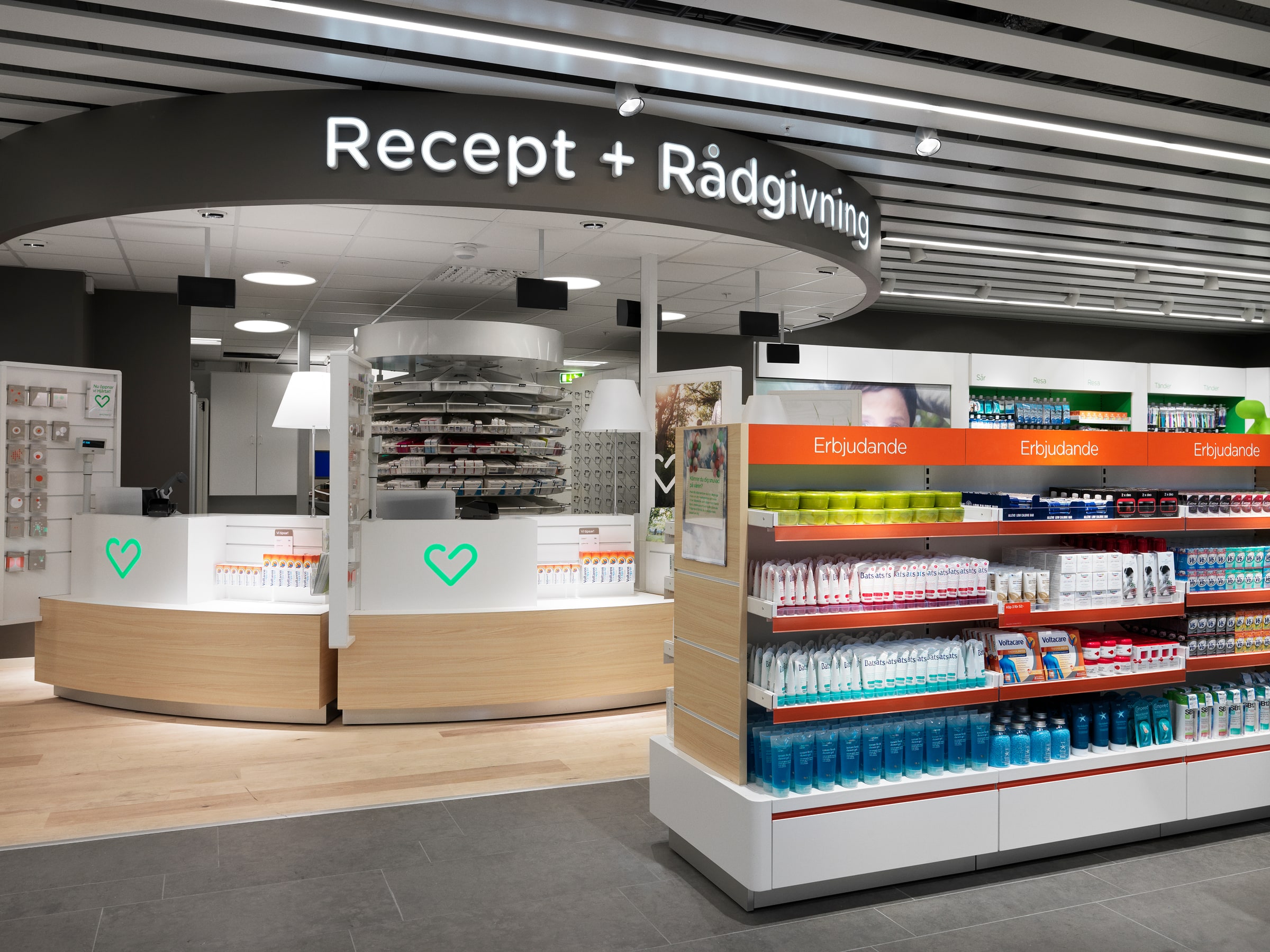 Curved prescription counter beneath a Recept + Rådgivning sign at Apotek Hjärtat in Tyresö