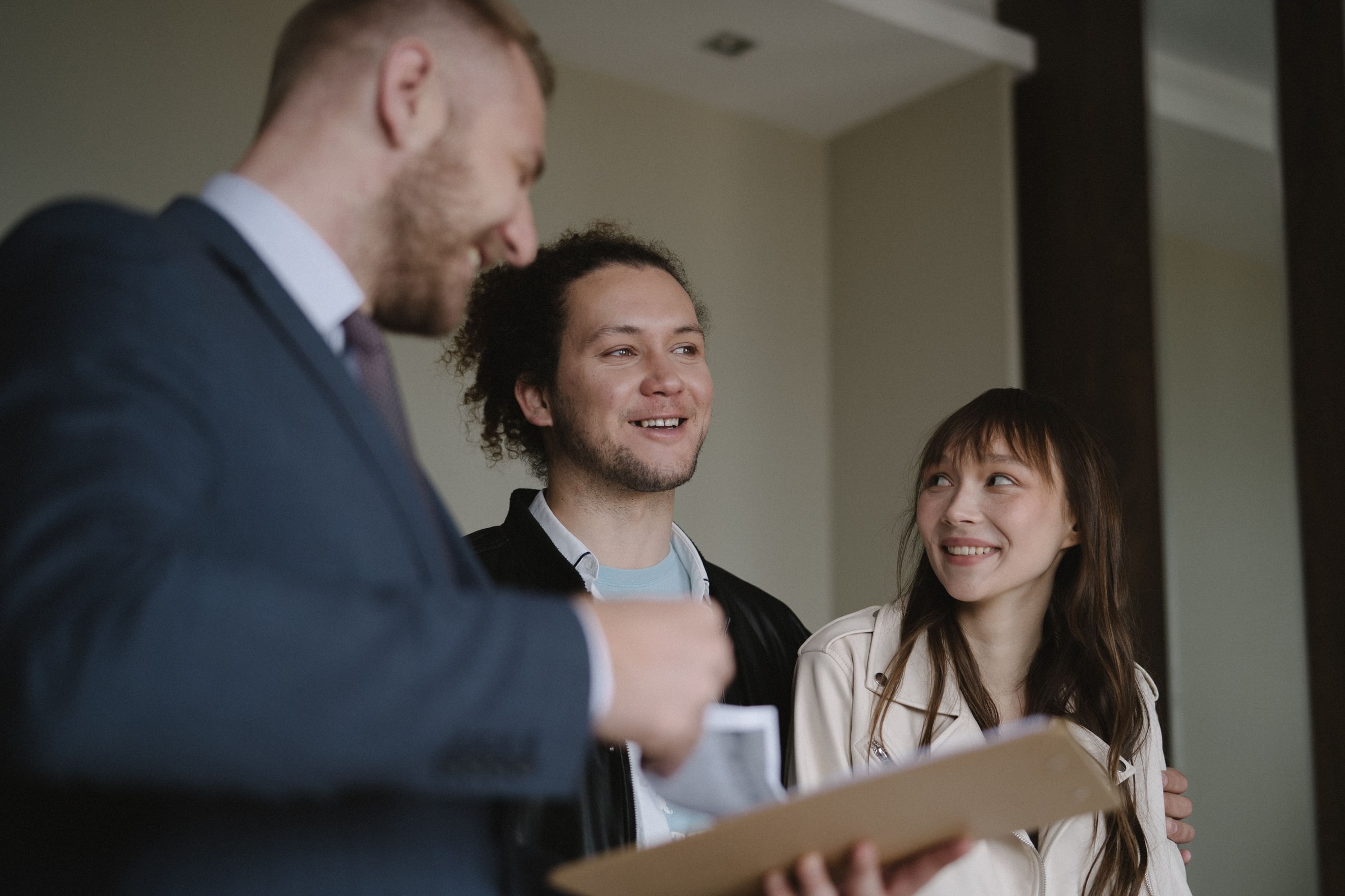 A couple speak with an agent during a home viewing.