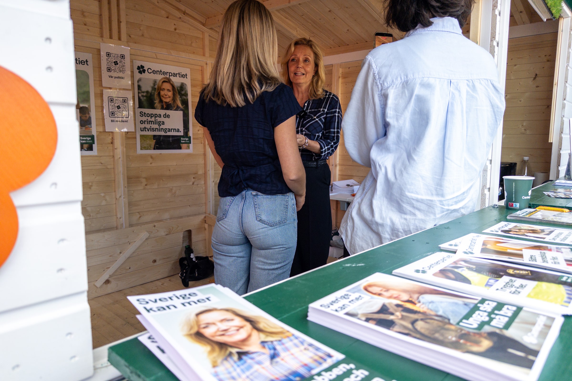Elisabeth Thand Ringqvist speaking with people inside a Centre Party campaign booth in Gothenburg in August 2026.