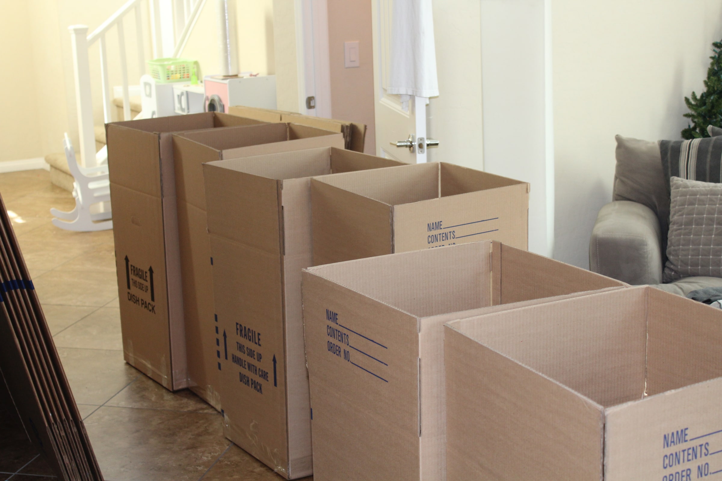 Six open cardboard moving boxes arranged inside a residential interior.
