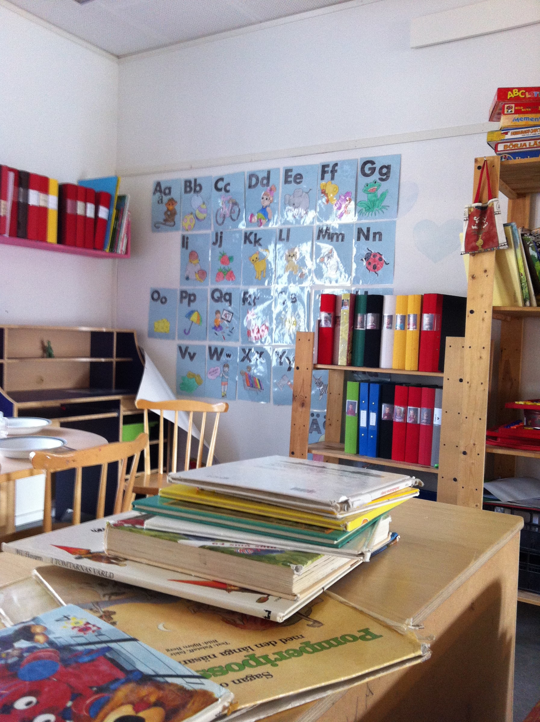 Alphabet posters, books and learning folders in a Swedish preschool reading-and-writing area.