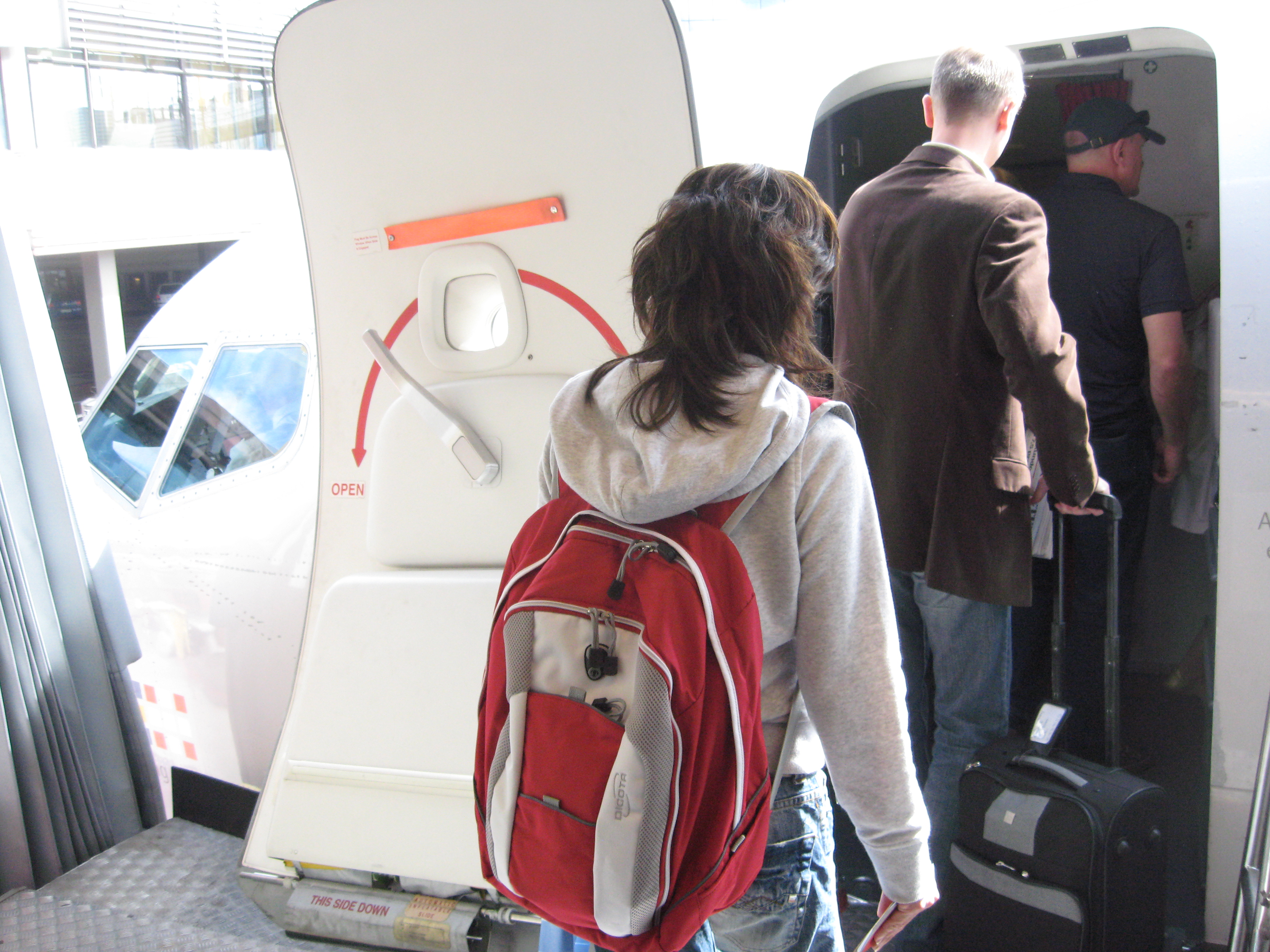 Passengers carrying bags board a plane at Stockholm Arlanda Airport.