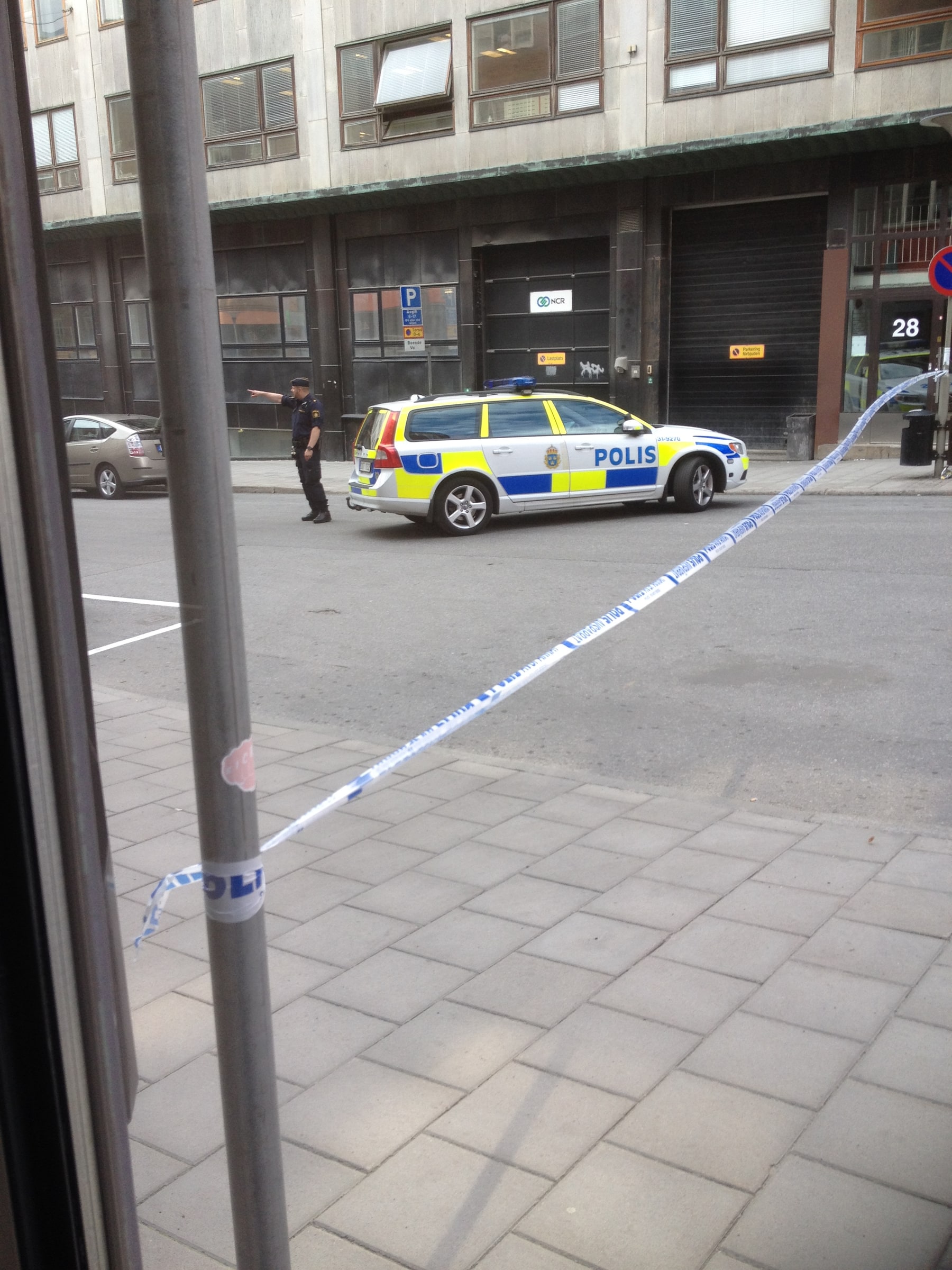 A Swedish police car and police cordon outside Hälsingegatan 28 in Stockholm.