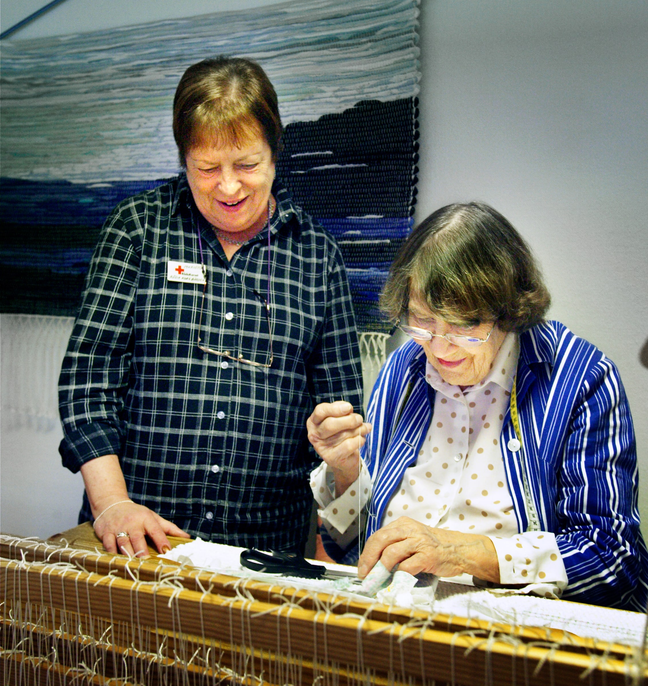 Two adults work together at a weaving loom during an adult-education activity in Norrtälje.