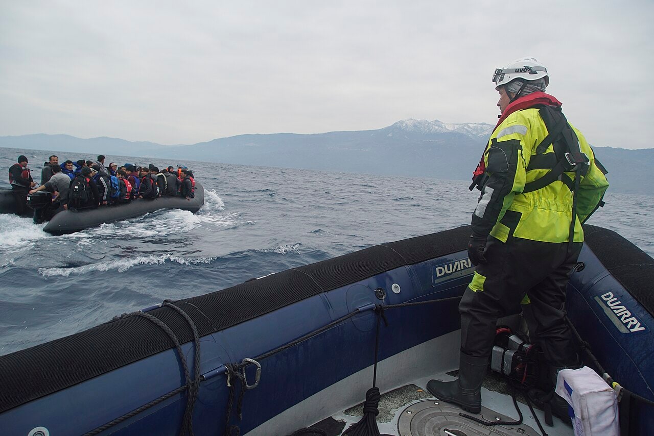 Refugees travel in an inflatable boat across the Mediterranean toward Lesbos in January 2016 as a rescue crew watches from another vessel.