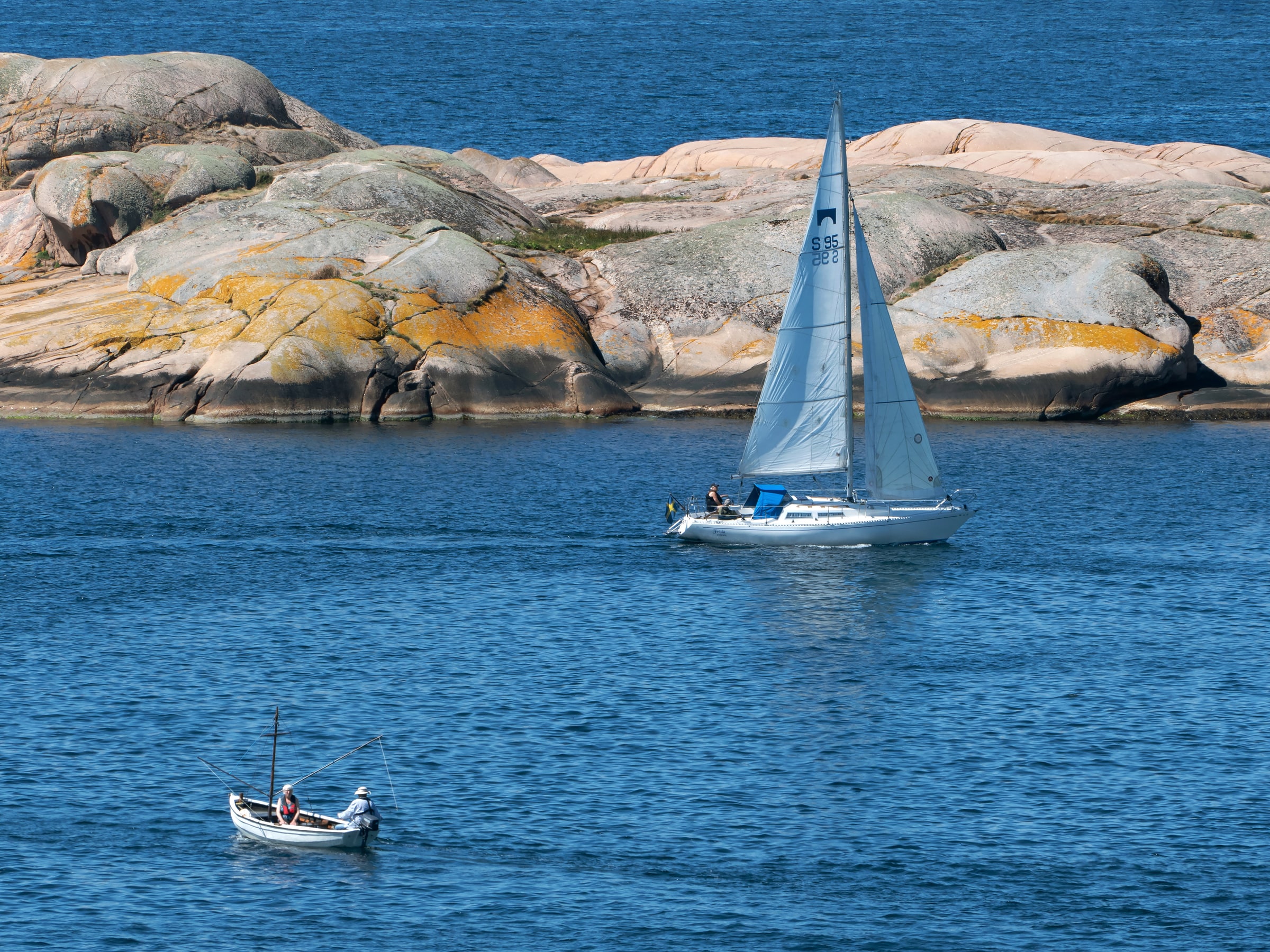 A sailboat passes rocky shores at Stångehuvud in Lysekil, Sweden.