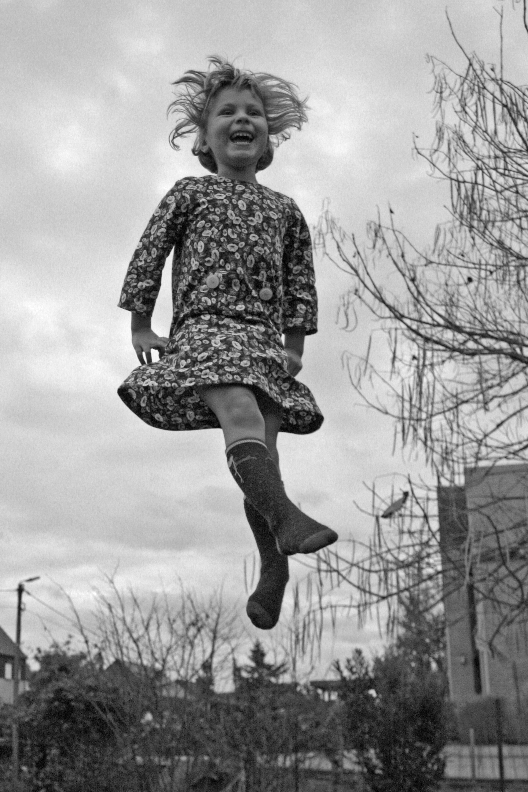 A person jumping high above a trampoline outdoors.