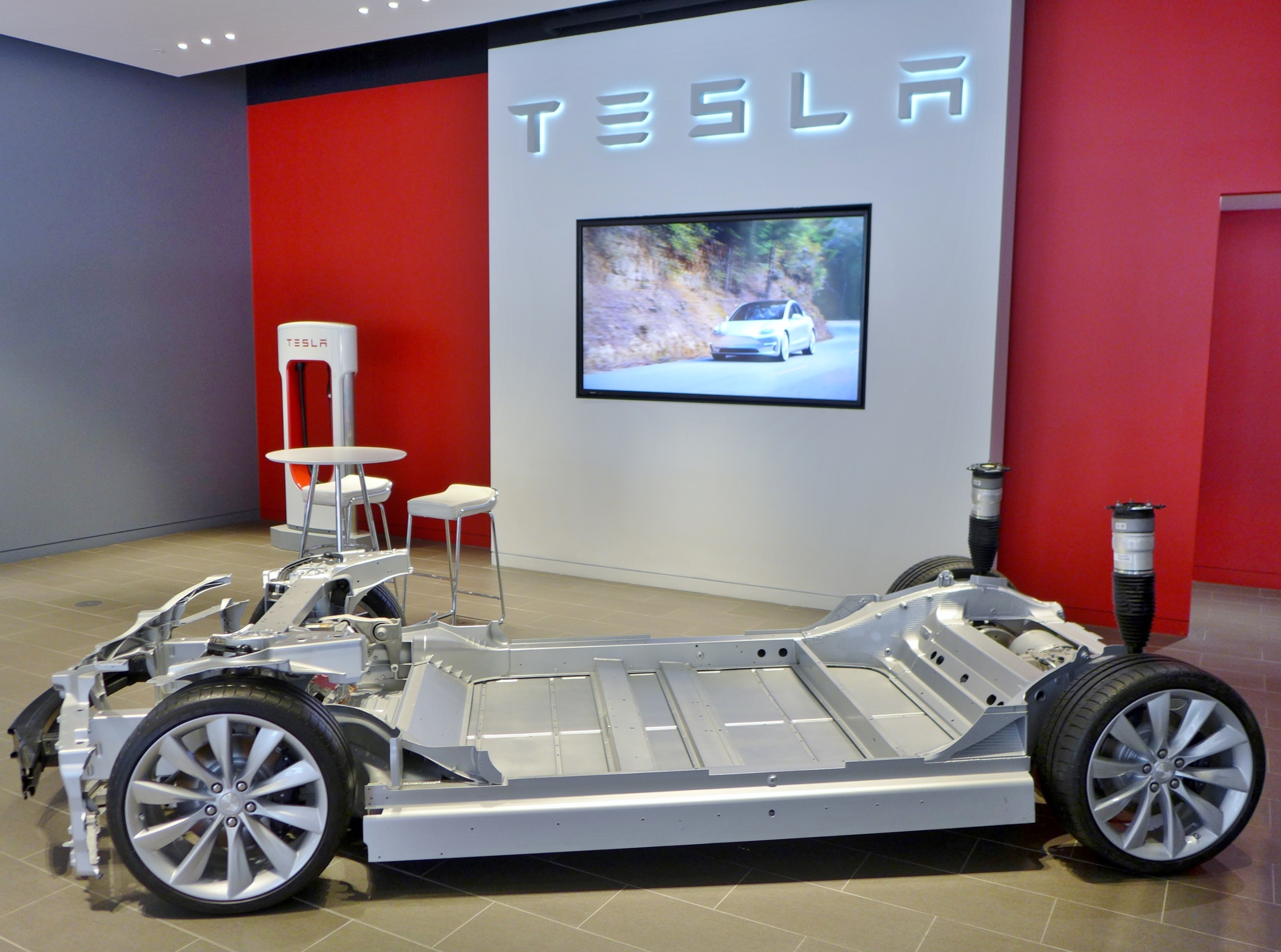 A Tesla Model S and Model X chassis displayed inside a Tesla showroom in Sydney.