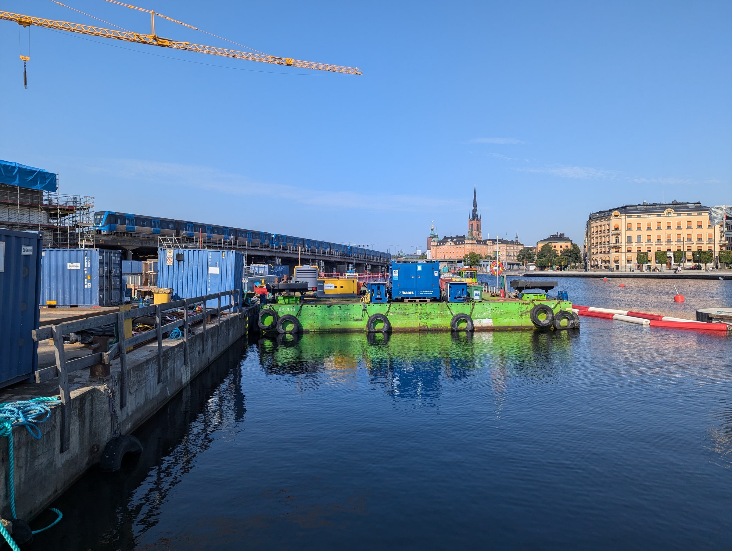 Workers and construction equipment on a barge at Slussen in Stockholm in September 2024.