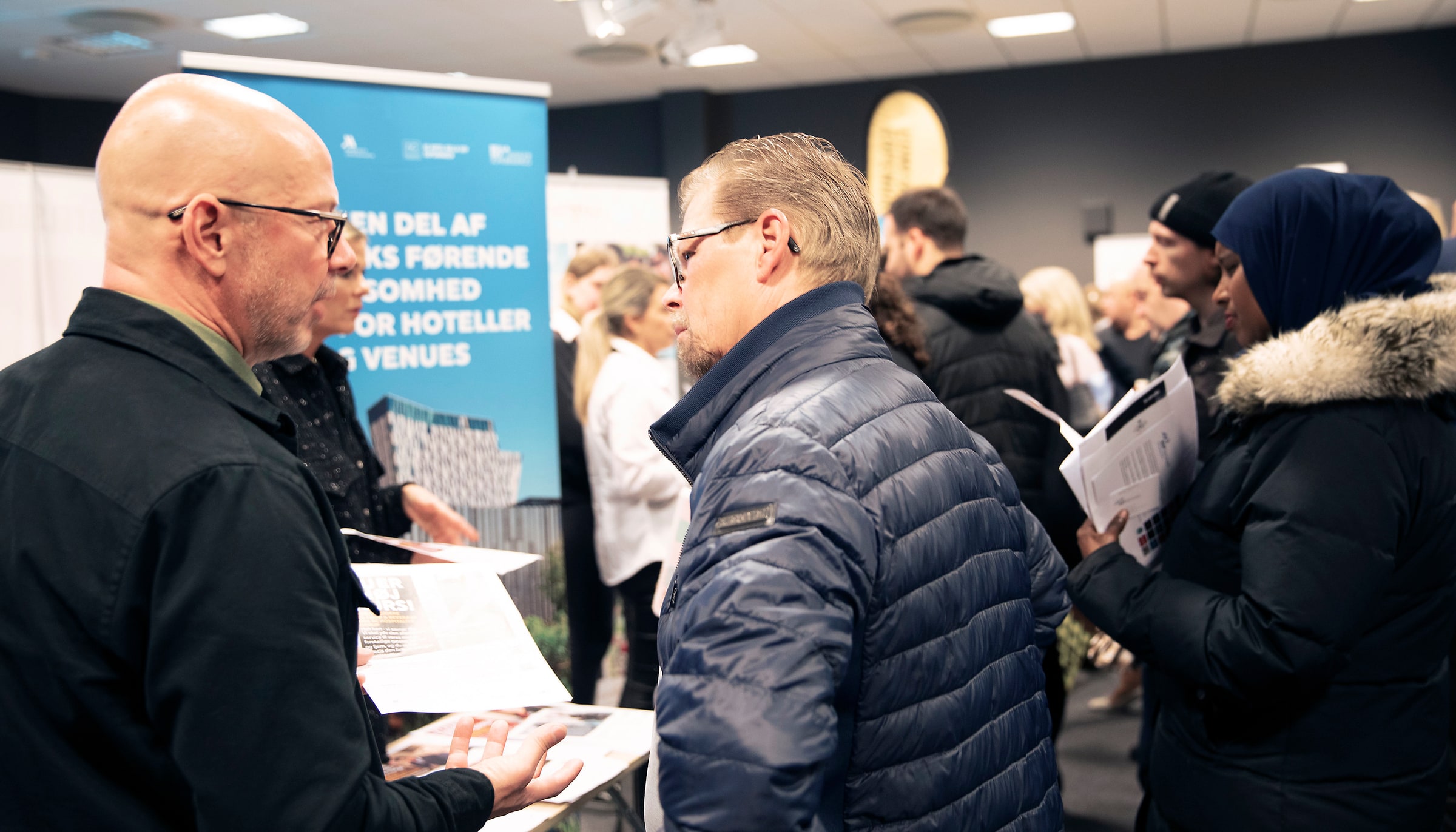 A visitor and recruiter speak across a table at Malmömässan in October 2021.