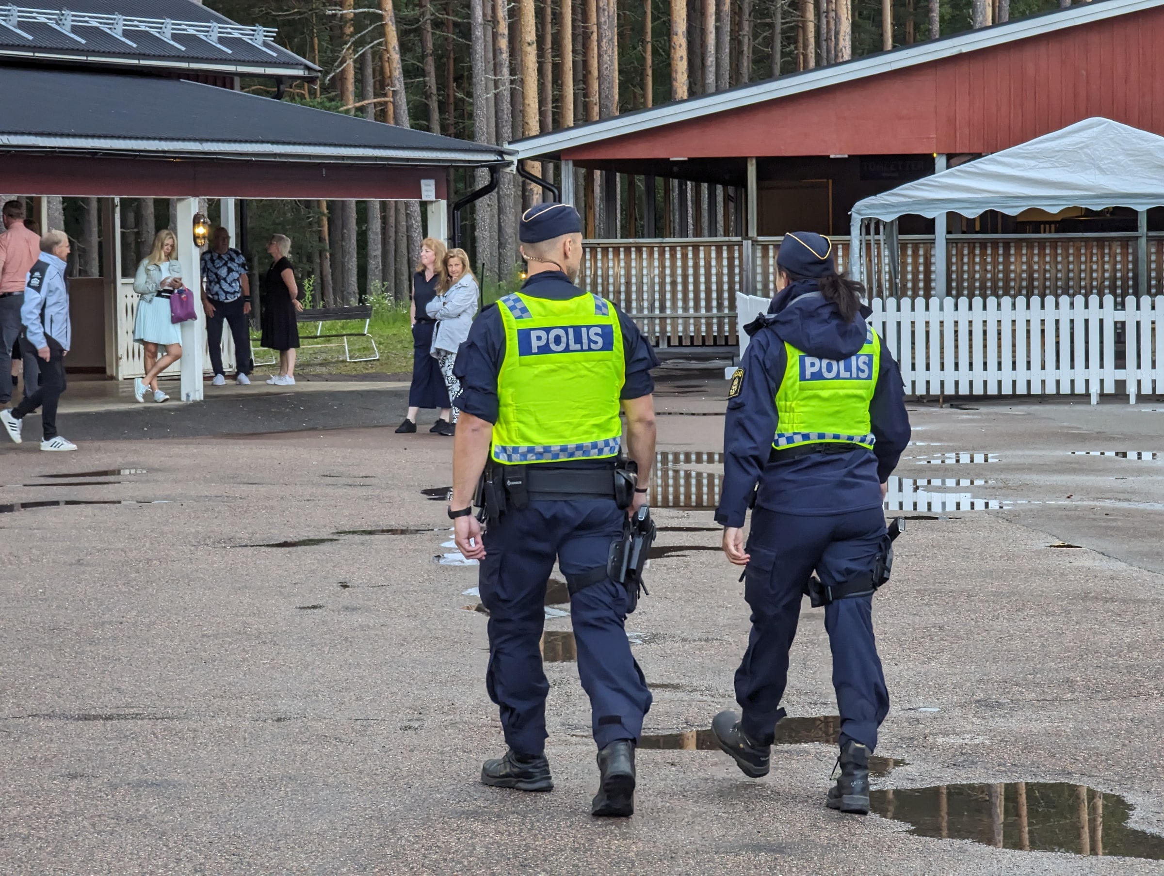 Two Swedish police officers walk on patrol in Orrskogen, Malung.