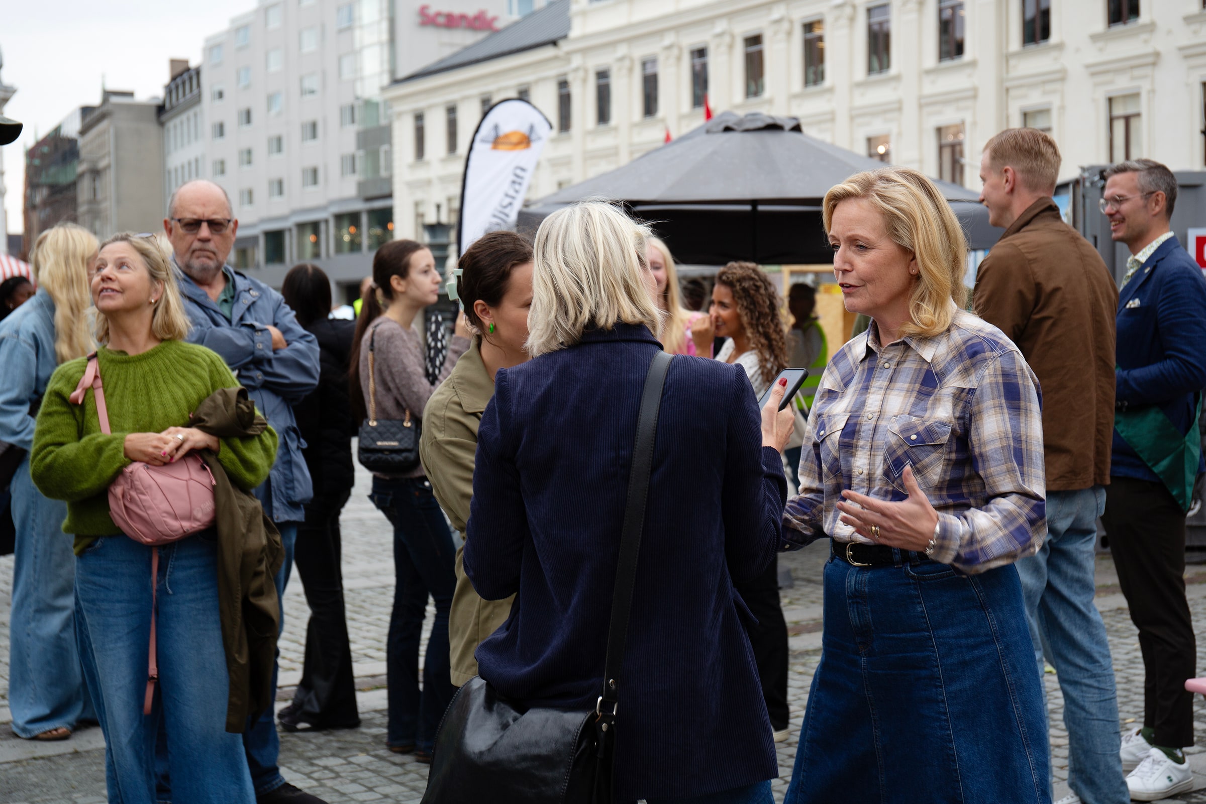 Elisabeth Thand Ringqvist gestures while speaking with people in a public square.