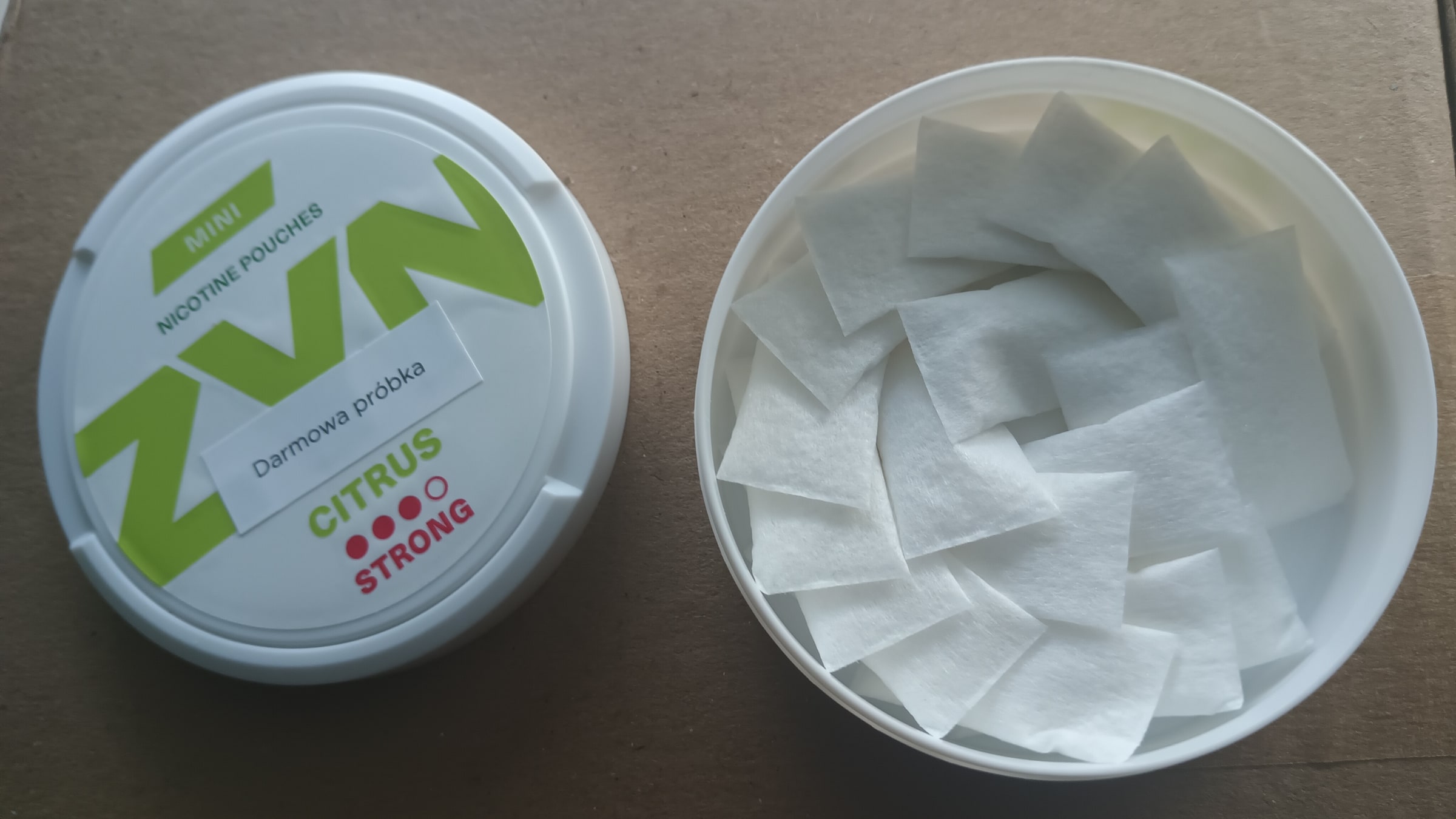 White nicotine pouches in an open container.
