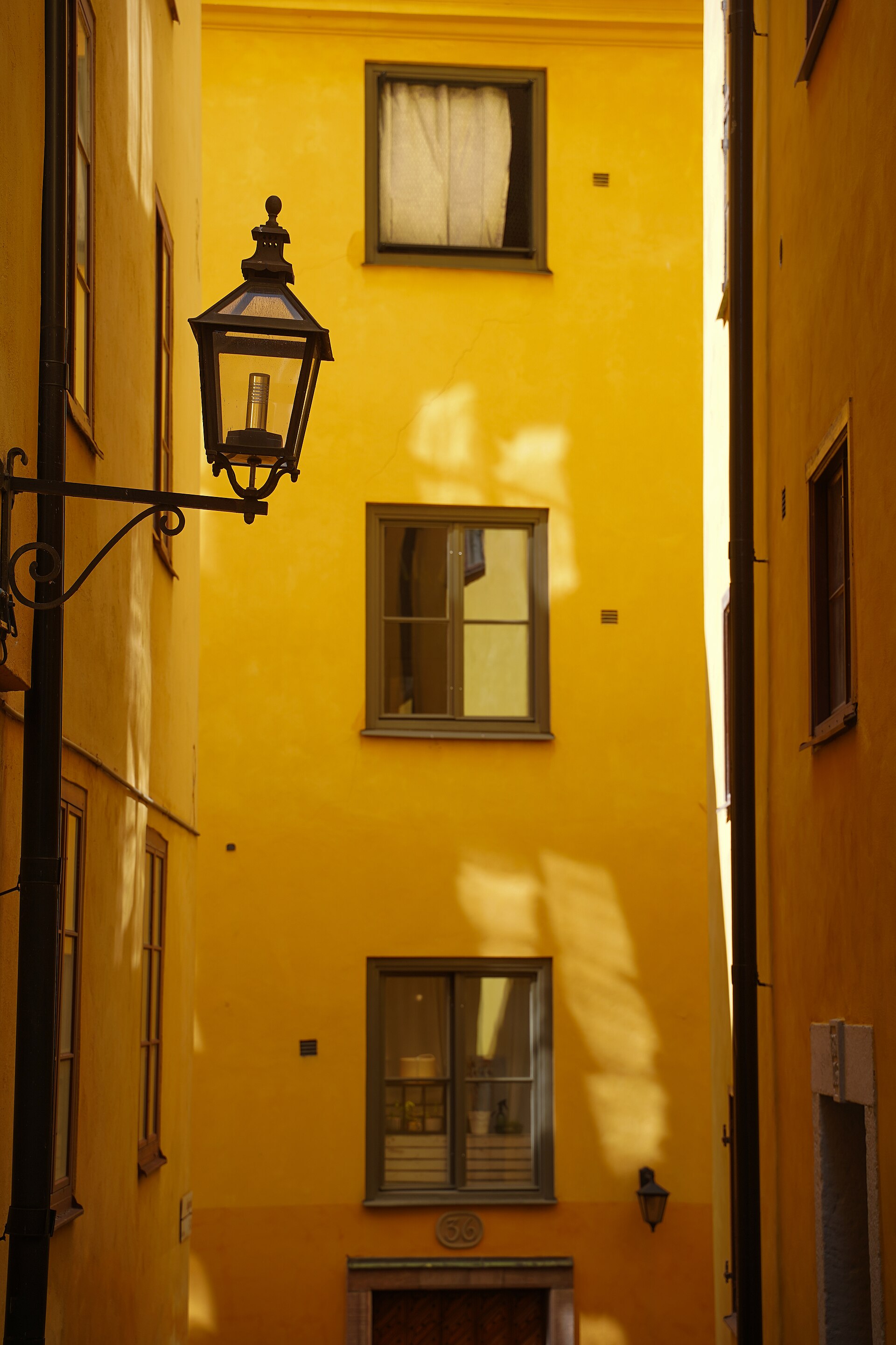 A yellow multi-storey residential building in an alley in Stockholm’s Gamla Stan.