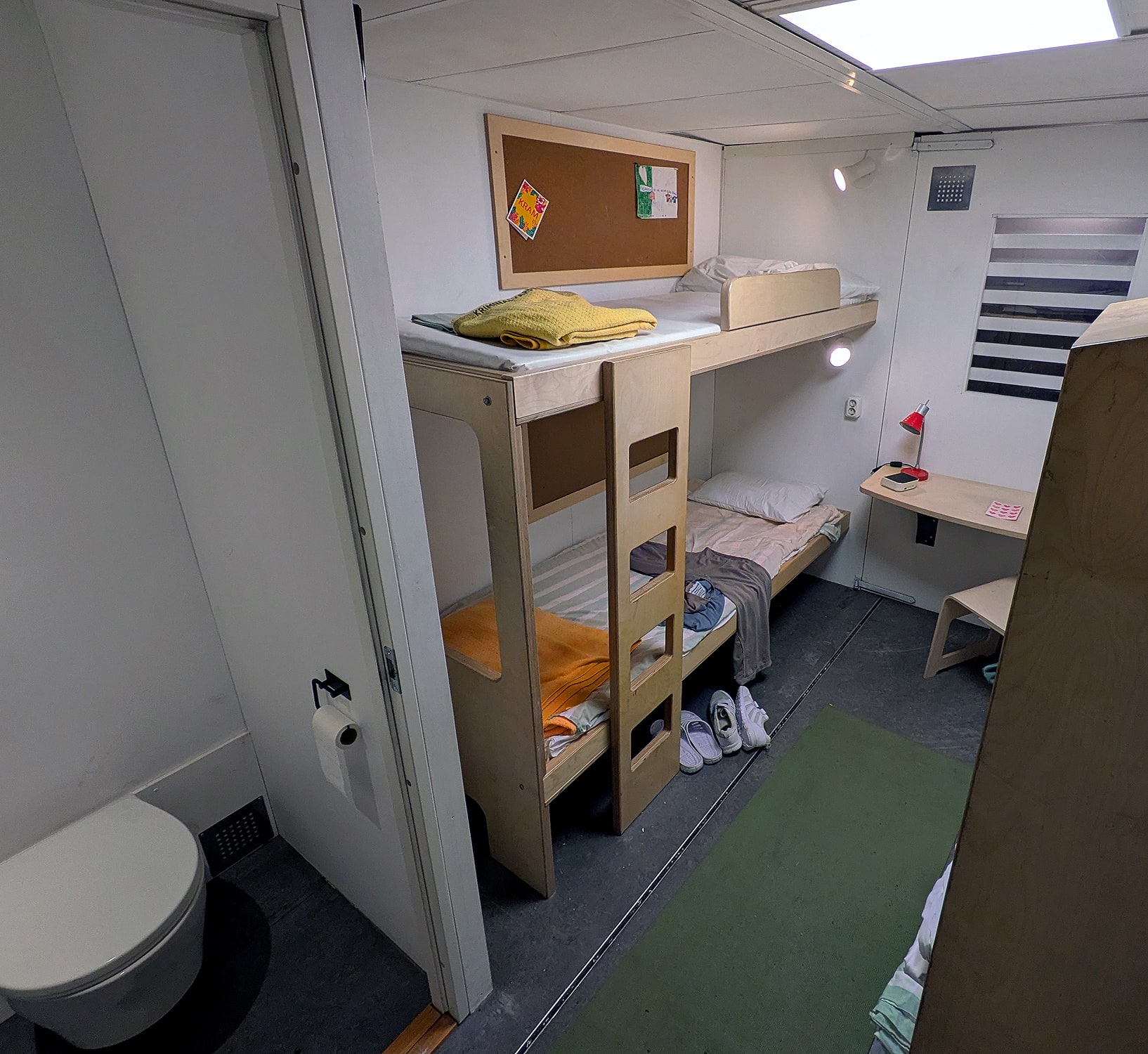 A full-scale prison-cell display with a bunk bed, toilet and small desk inside Kriminalvarden's recruitment bus.
