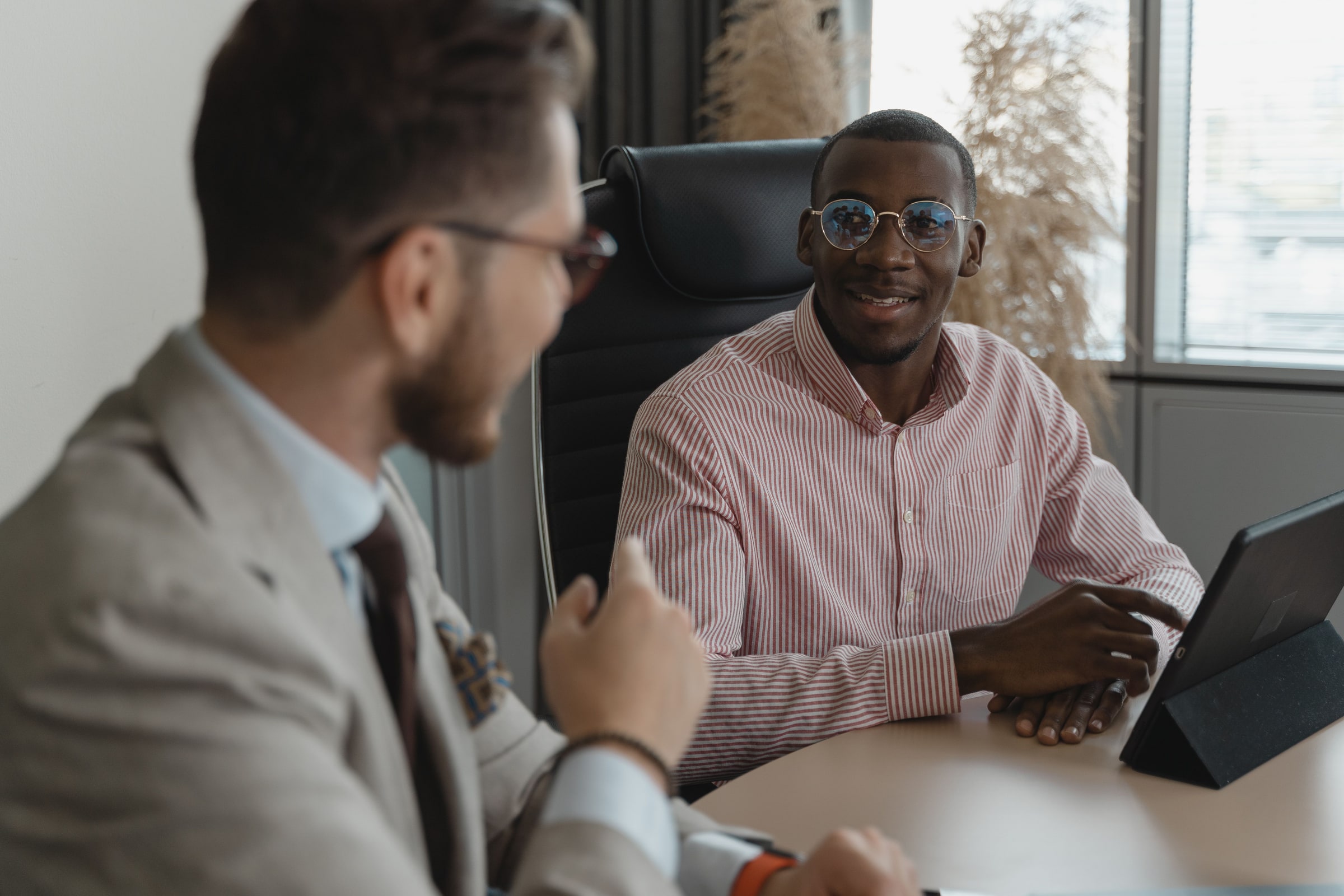Two adults talk across a desk during a job interview.