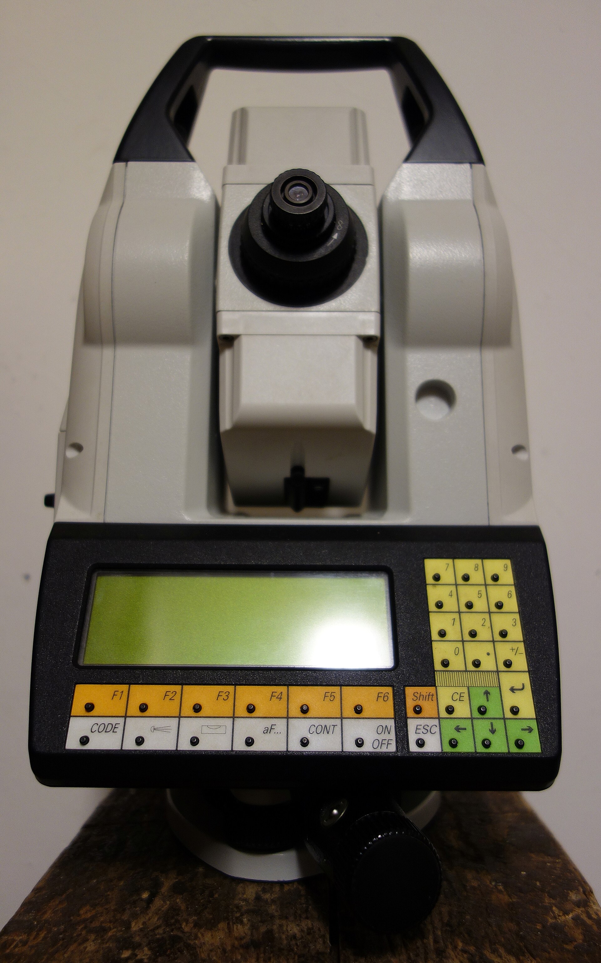 A Leica total station surveying instrument mounted on a tripod.