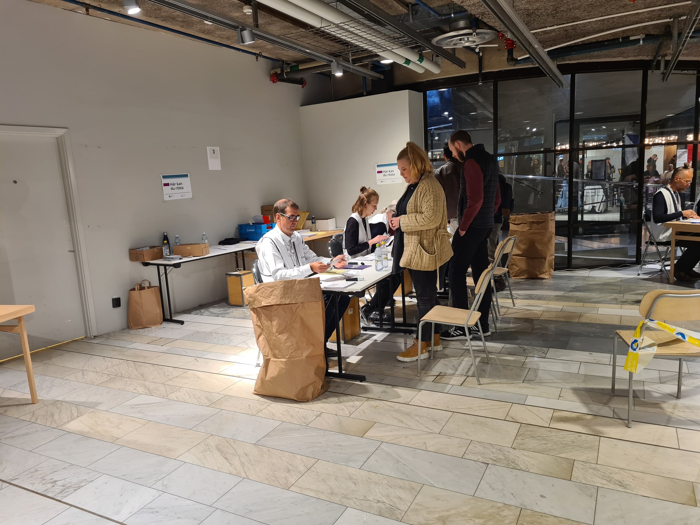 A voter presents voting materials to election workers at a Swedish polling place in September 2022.