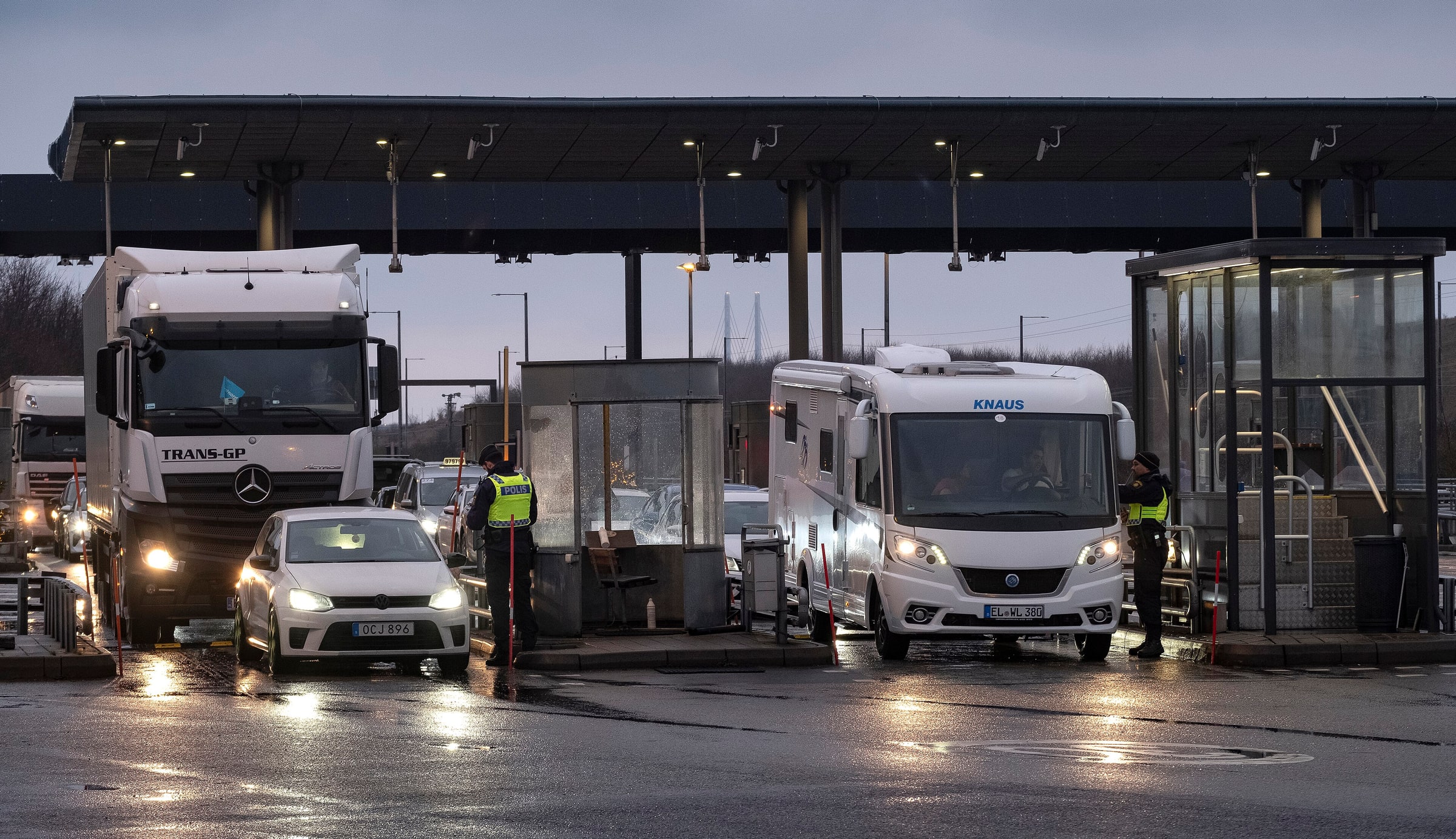 Swedish police officers check vehicles at the Öresund Bridge border-control lanes in Malmö.