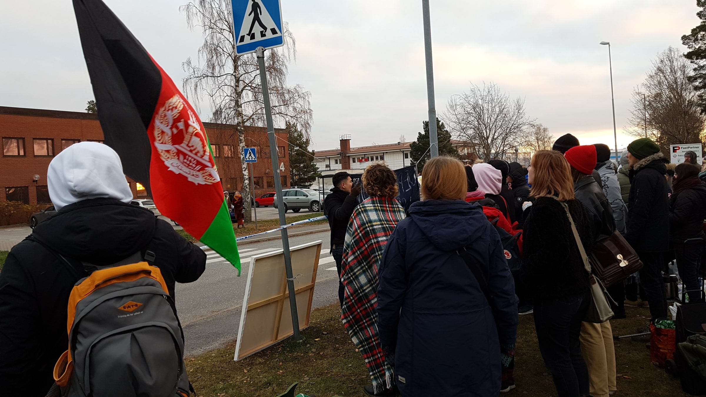 An Afghan flag rises above demonstrators gathered outside the Swedish Migration Agency detention centre in Märsta in November 2018.