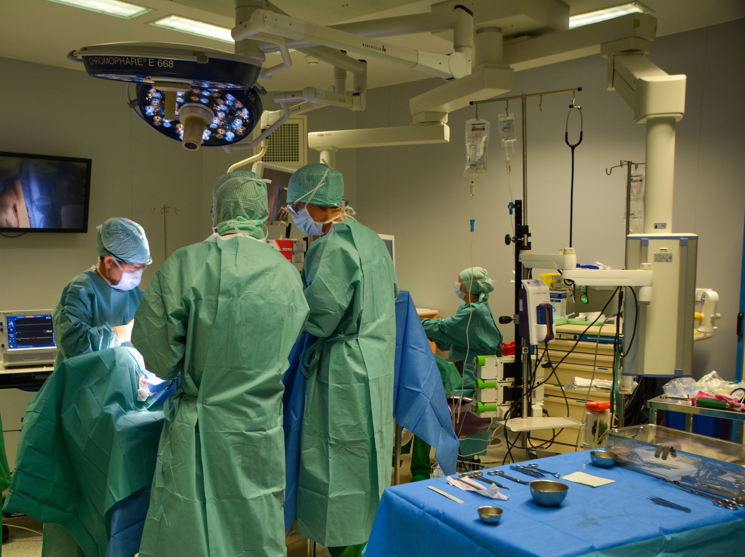 A surgical team performs an operation in a hospital operating room.