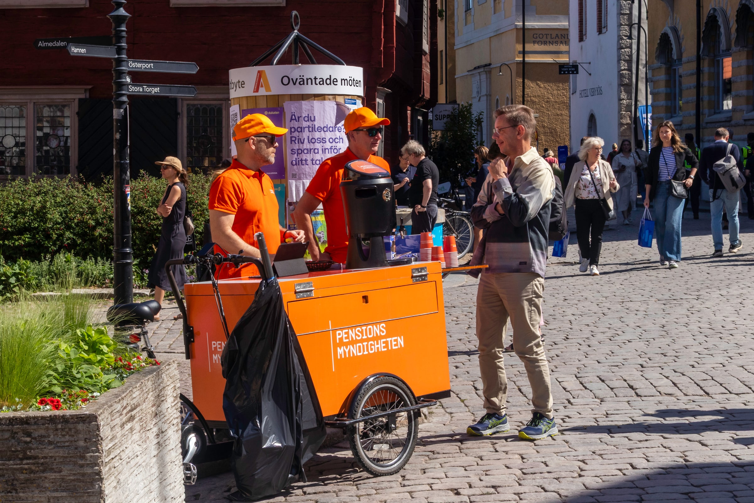 Pensionsmyndigheten staff beside an orange outreach cart at Almedalen in June 2025.