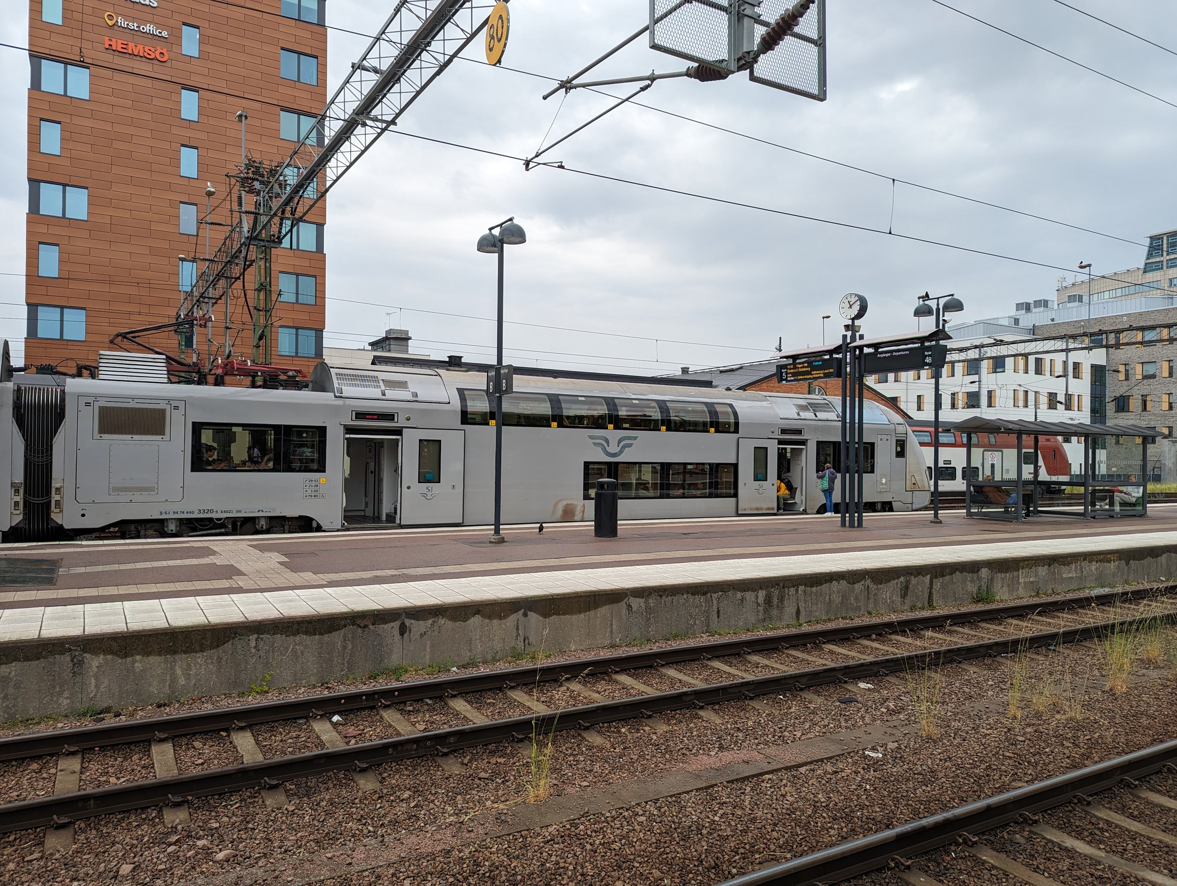 An SJ double-deck passenger train beside a platform at Västerås station.