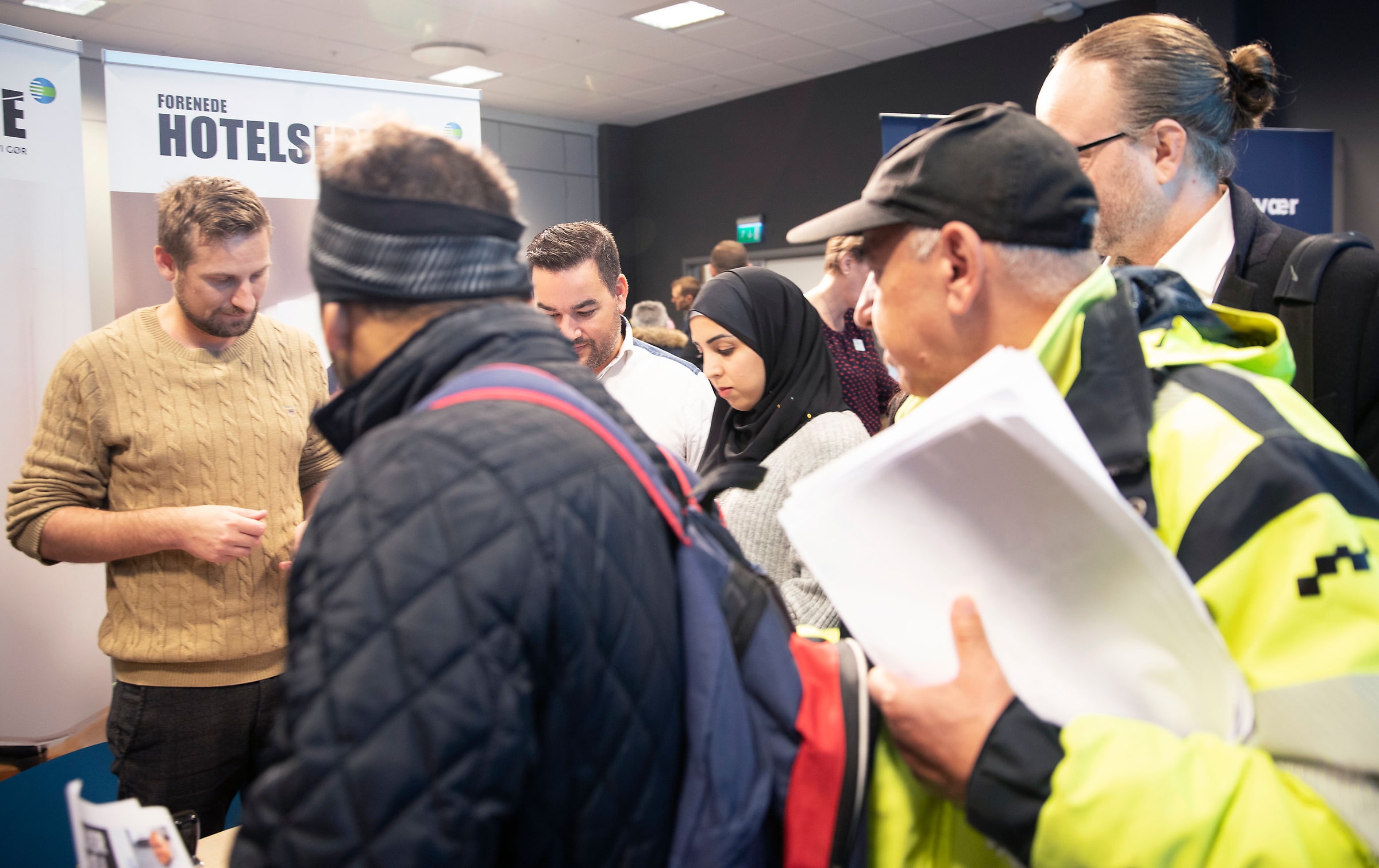 Visitors holding papers gather around recruiters at Malmömässan in October2021.