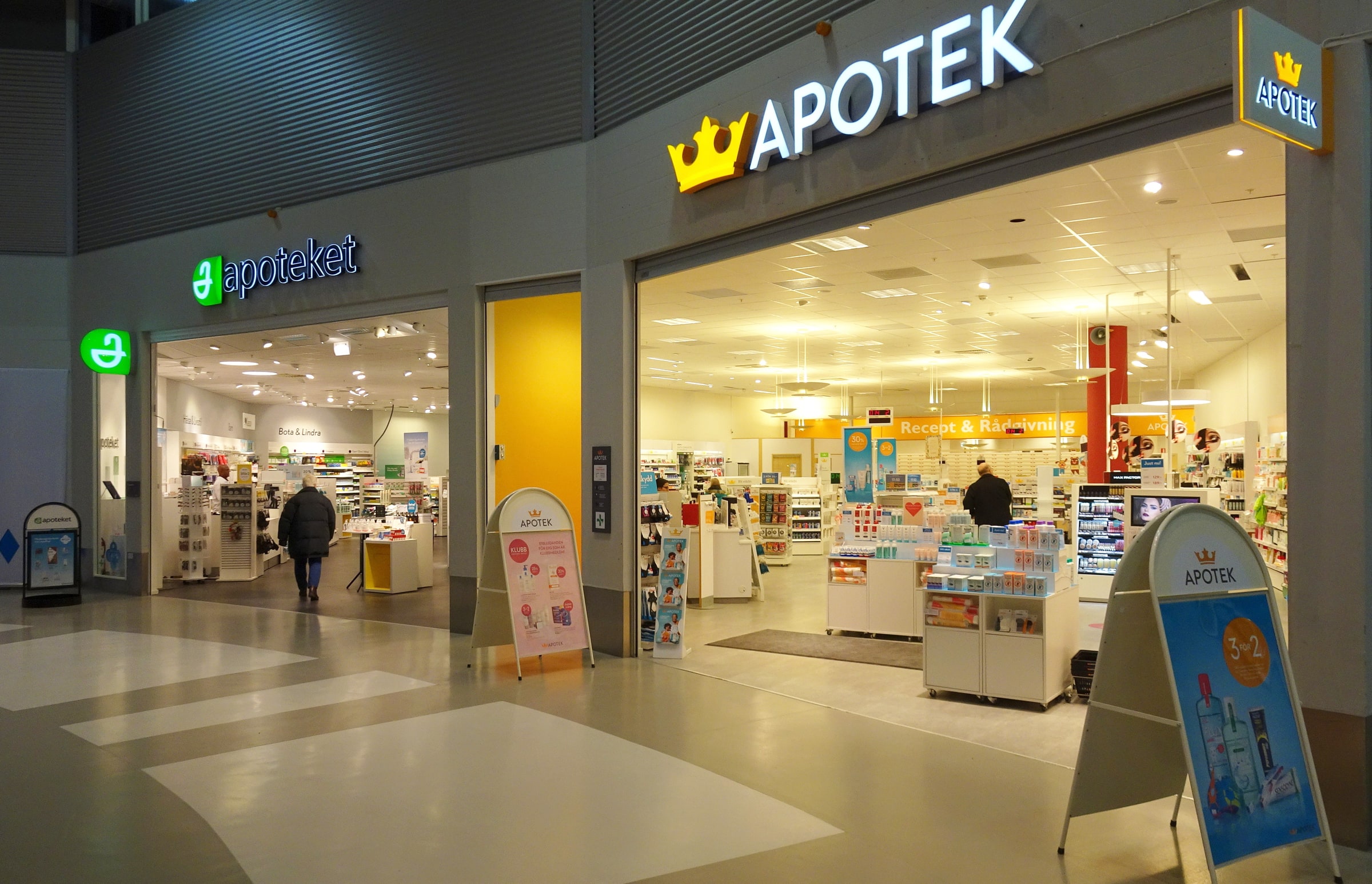 Apoteket and Kronans Apotek pharmacy entrances side by side at Kungens Kurva in 2016