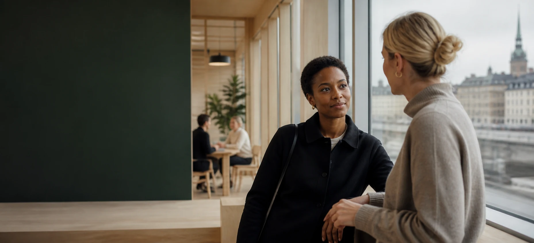 Two professionals talking in a bright Stockholm workplace.